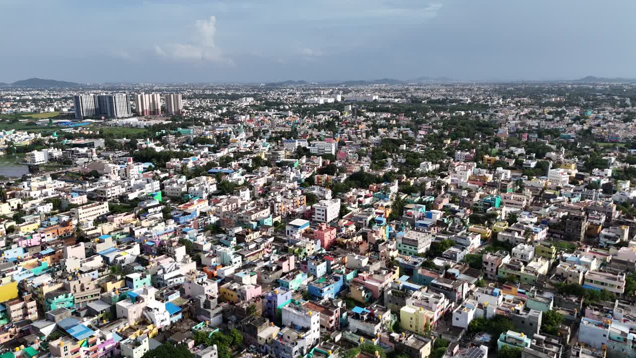 Aerial footage provides a bird's-eye view of a vibrant and densely packed residential area in an Indian city. Colorful tapestry of homes and buildings