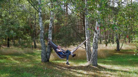 Hombre-Relajándose-En-Una-Hamaca-Entre-árboles-En-Pradzonka,-Polonia