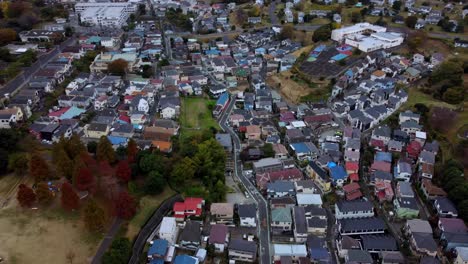 Una-Densa-Zona-Residencial-Con-Techos-De-Colores-Variados-En-Un-Día-Nublado,-Otoño,-Vista-Aérea