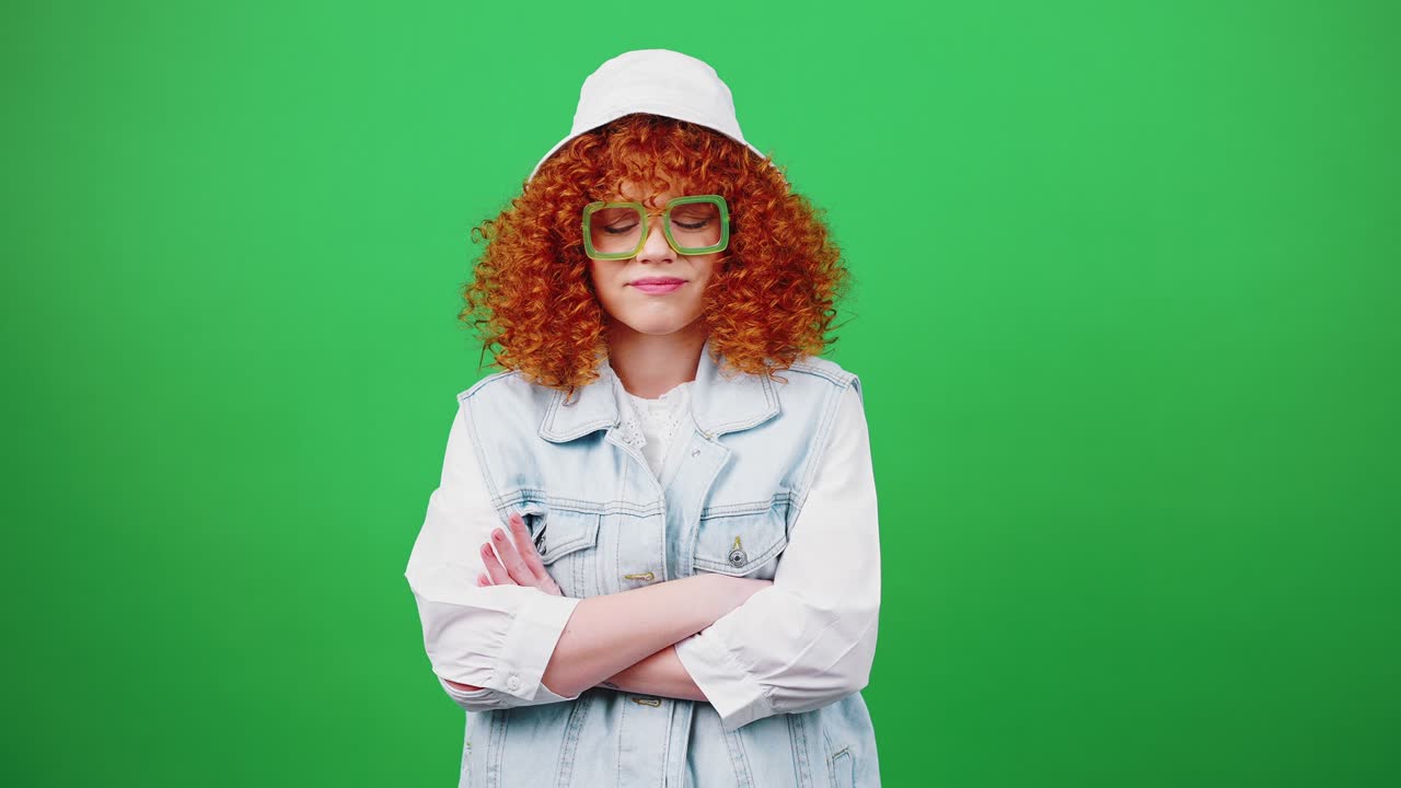 cattiva idea. giovane signora dai capelli rossi ricci che guarda la telecamera con dubbio, coprendo la faccia con un cappello panamense, esprimendo noia