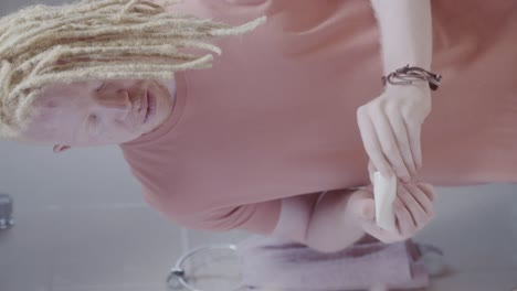 person with albinism applying skincare product