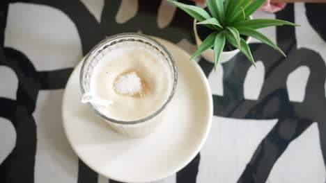 person hand stirring coffee with spoon