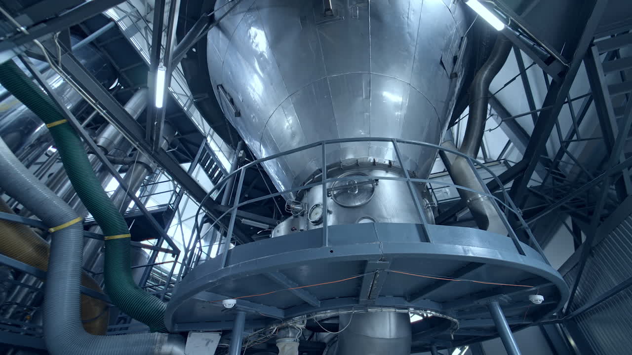 Big steel construction of milk factory. Modern food pipelines technology.