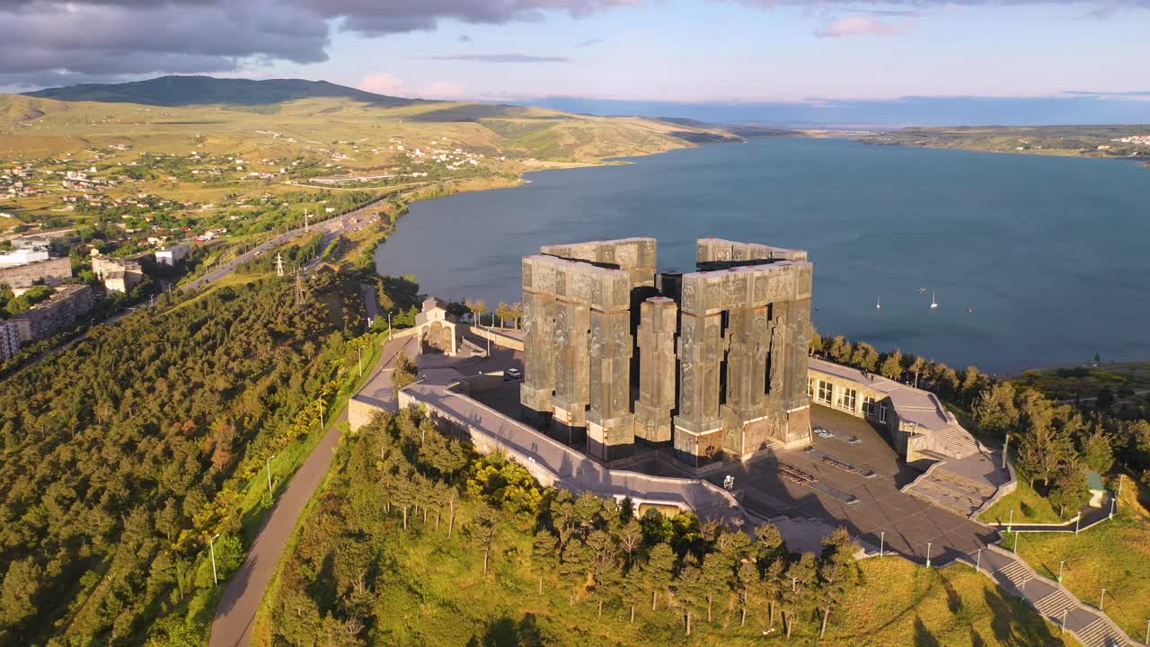 Aerial: Chronicle of Georgia at sunset, beautiful monument on Tbilisi hilltop