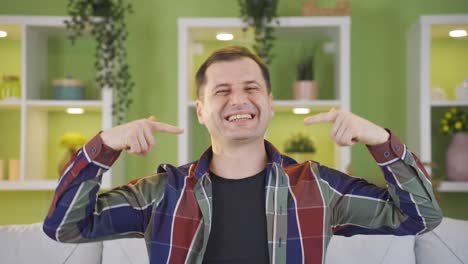 el hombre sonríe mostrando sus dientes mientras sonríe hacia la cámara.