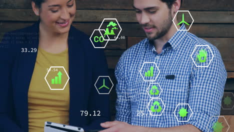 animación de iconos de ecología sobre diversos colegas que usan tableta en la oficina