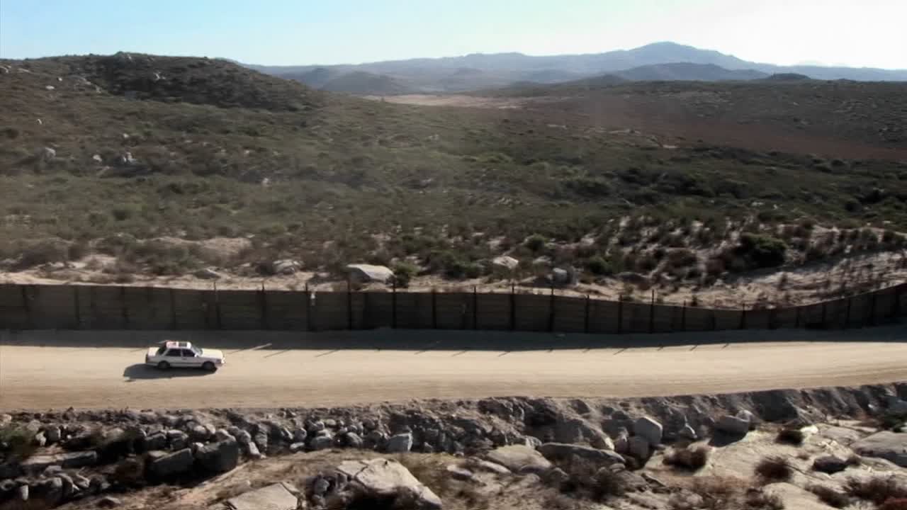 un coche conduce a lo largo de una carretera rural