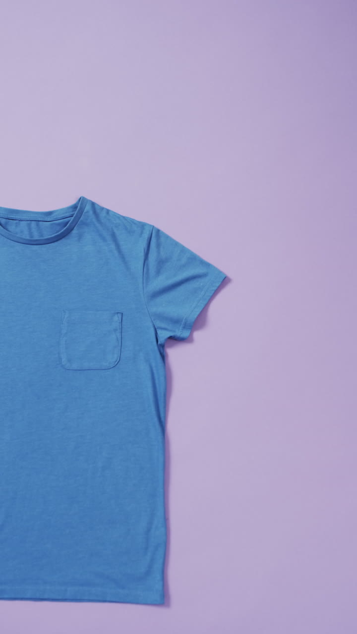 Vertical video of blue t shirt and copy space on purple background