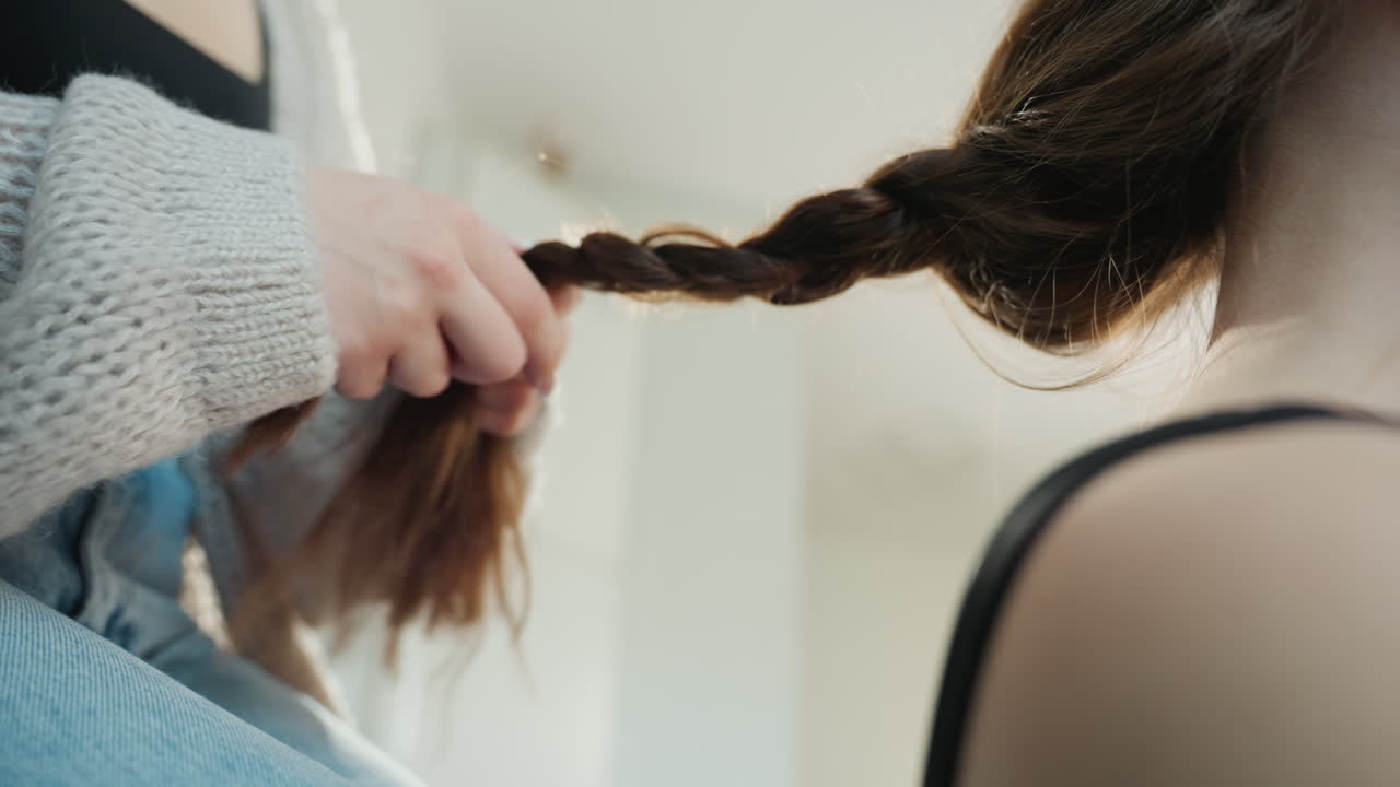 Caucasian Woman Prepped For Photoshoot With Braid Stylist Smoothing Long Hair Over Shoulder, Studio Mood, Black Tank Top, Clean Neck And Back Composition, Editorial Preparation And Poised Styling