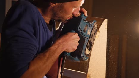 carpenter using belt sander on wooden project