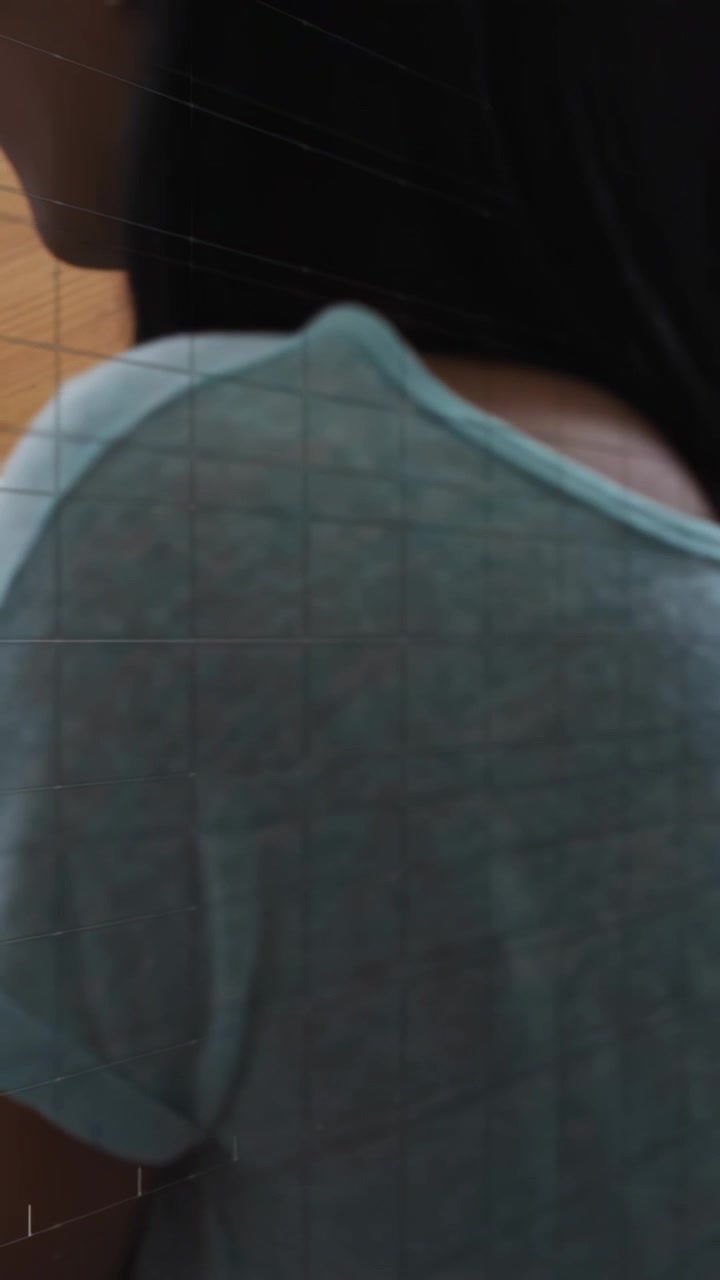 Video verticale: Donna che inizia una lenta rotazione della testa, rivelando un top color verde acqua, la mascella e il soffitto per la salute