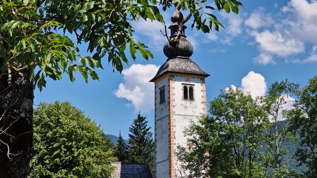 Katholischer Kirchturm in einem Dorf in den europäischen Alpen an einem heißen sonnigen Sommertag