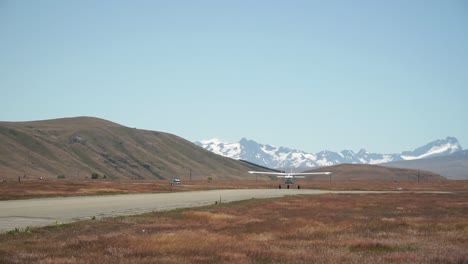 Airplane-taking-off-with-snow-capped-rocky-mountains-in-background