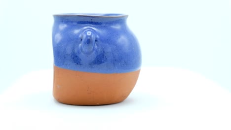 escena cristiana del nacimiento en un pequeño jarrón de terracota sobre un fondo blanco.
