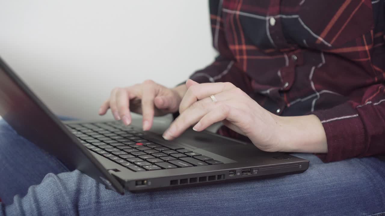 Caucasian female girl is writing on her laptop keyboard - detail of typing hands