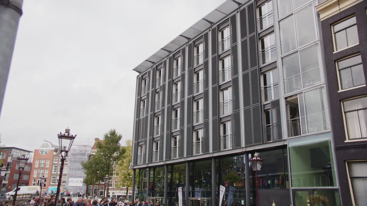 Tilt down to large crowd of tourists in front of Anne Frank House museum entrance