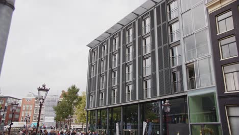 tilt down to large crowd of tourists in front of anne frank house museum entrance