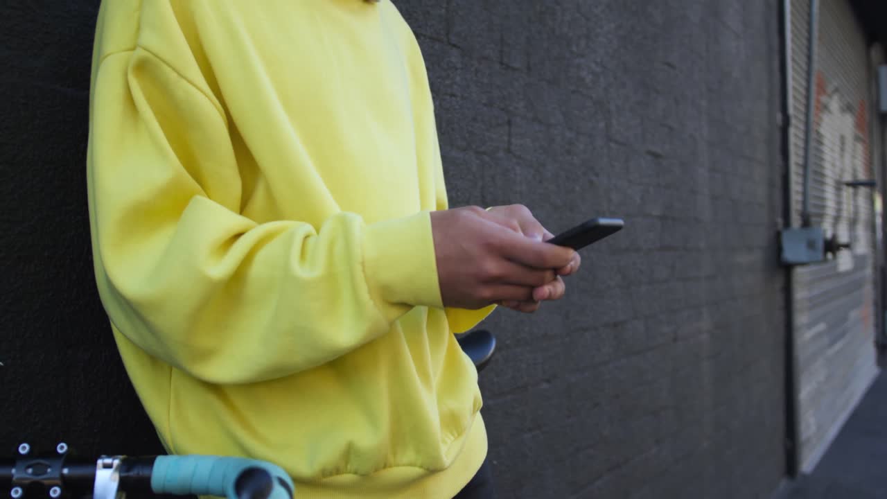adulto transgénero con una bicicleta y usando un teléfono