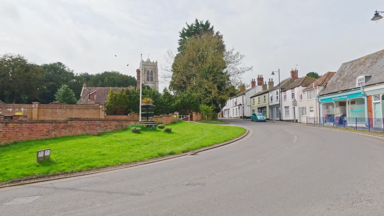 Videoklip af bygninger og butikker med sognekirken i den historiske købstad Burgh le Marsh ved udkanten af Lincolnshire Wolds