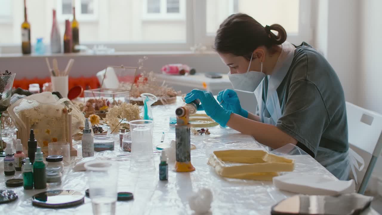Woman creating resin art in a craft workshop