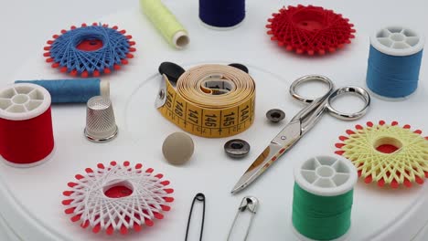 Sewing-tools-and-accessories:-scissors,-tape-measure,-spools-of-thread,-thimble-and-pins-isolated-on-white-background