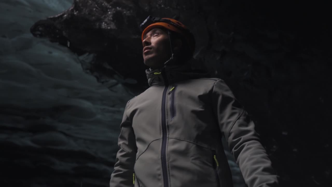 Man standing in an ice cave formation in the Vatnajökull Glacier in Iceland