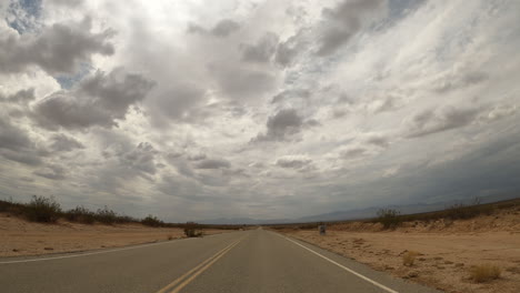 Driver-point-of-view-of-a-road-through-the-vast-landscape-of-the-Mojave-Desert---hyper-lapse