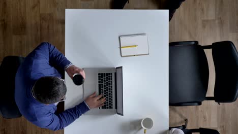 topshot of business people working in modern office, camera moving above businessmen sitting at table, concentrated and busy