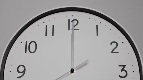 close up, time lapse, white wall clock with short hands showing twelve o'clock.