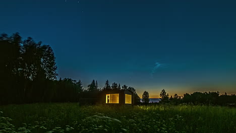 Wooden-shelter-in-green-countryside-landscape-with-people-indoors