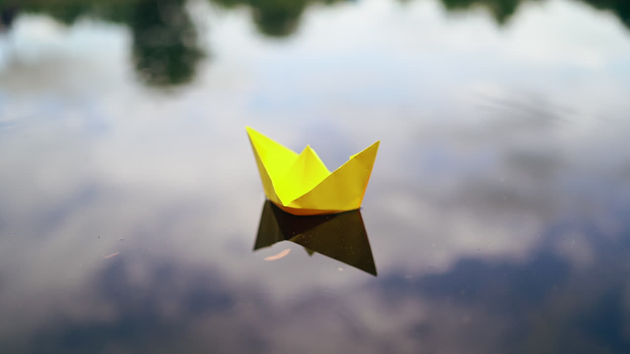 Paper ship in woman hand. Woman putting paper boat into water