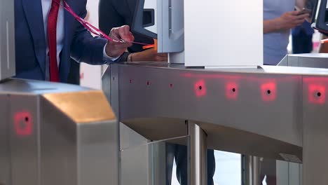 man using access card at turnstile