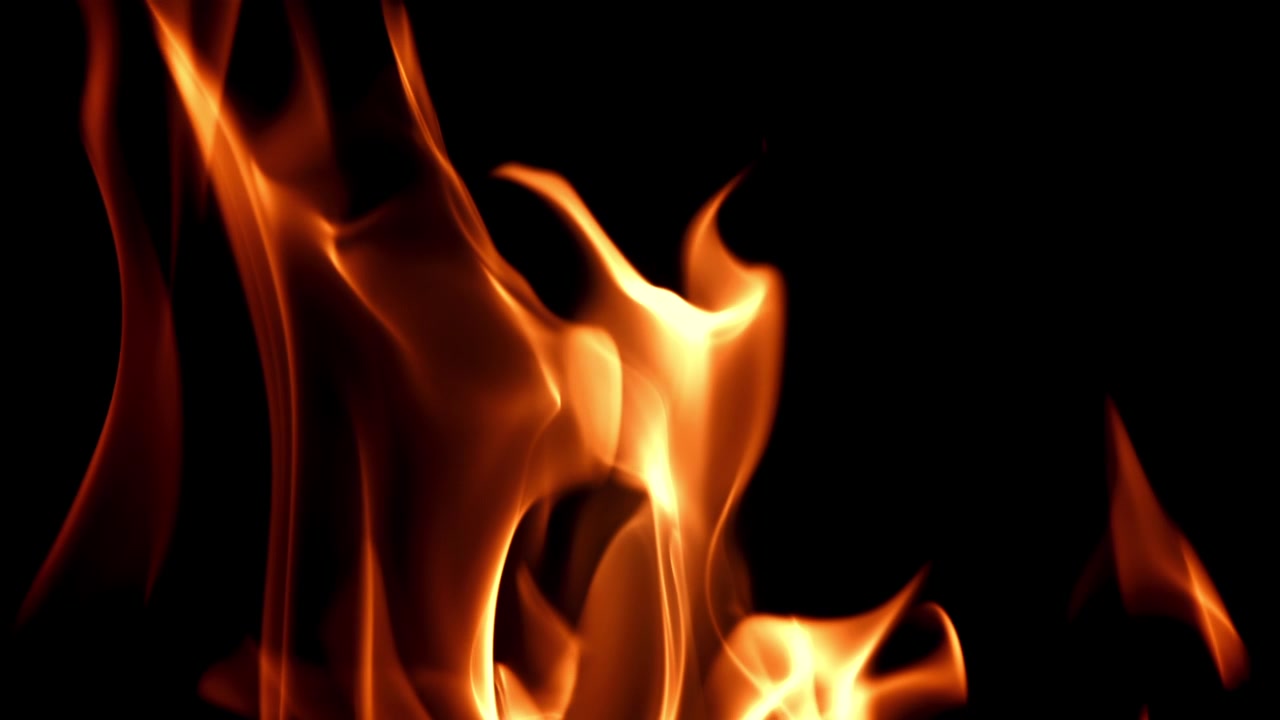 Slowmotion ildflammer brænder på sort baggrund.