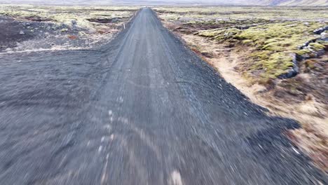 a drone view of a car passing from barren land on a road towards its destination, iceland