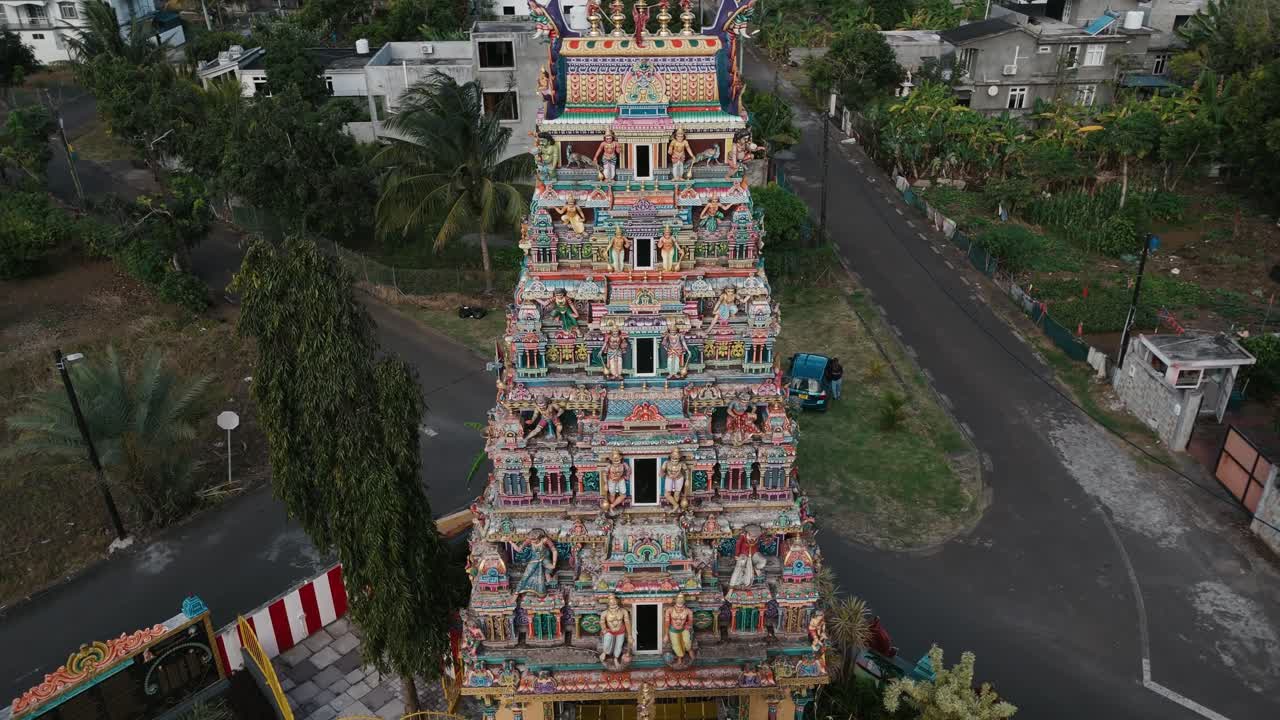 Aerial orbit of Tamil Hindu temple tower showing intricate carvings and colorful exterior patterns