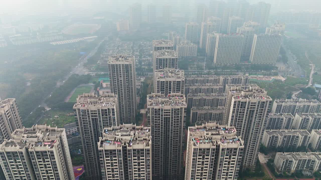 Aerial: Chongqing outskirt in a residential area with pollution during the day in Yuzhong District, China, pull out drone shot