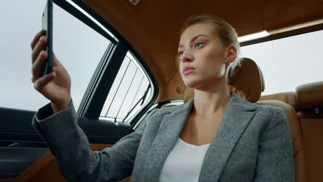 Closeup-focused-executive-woman-making-video-chat-at-vehicle.-Woman-using-mobile