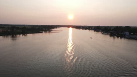 sun setting down, aerial view from middle of vast river