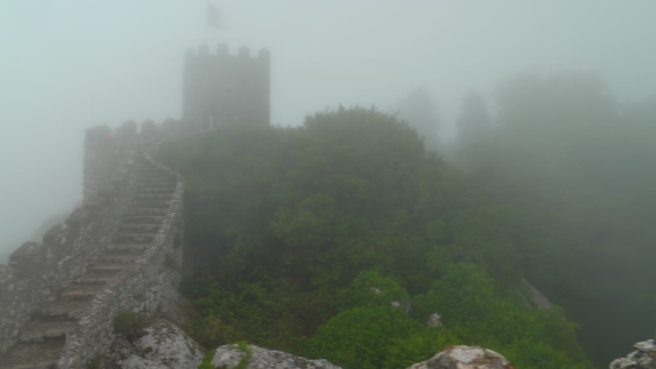 vista panorámica del castillo de los moros con una densa niebla húmeda que sopla a través de los árboles