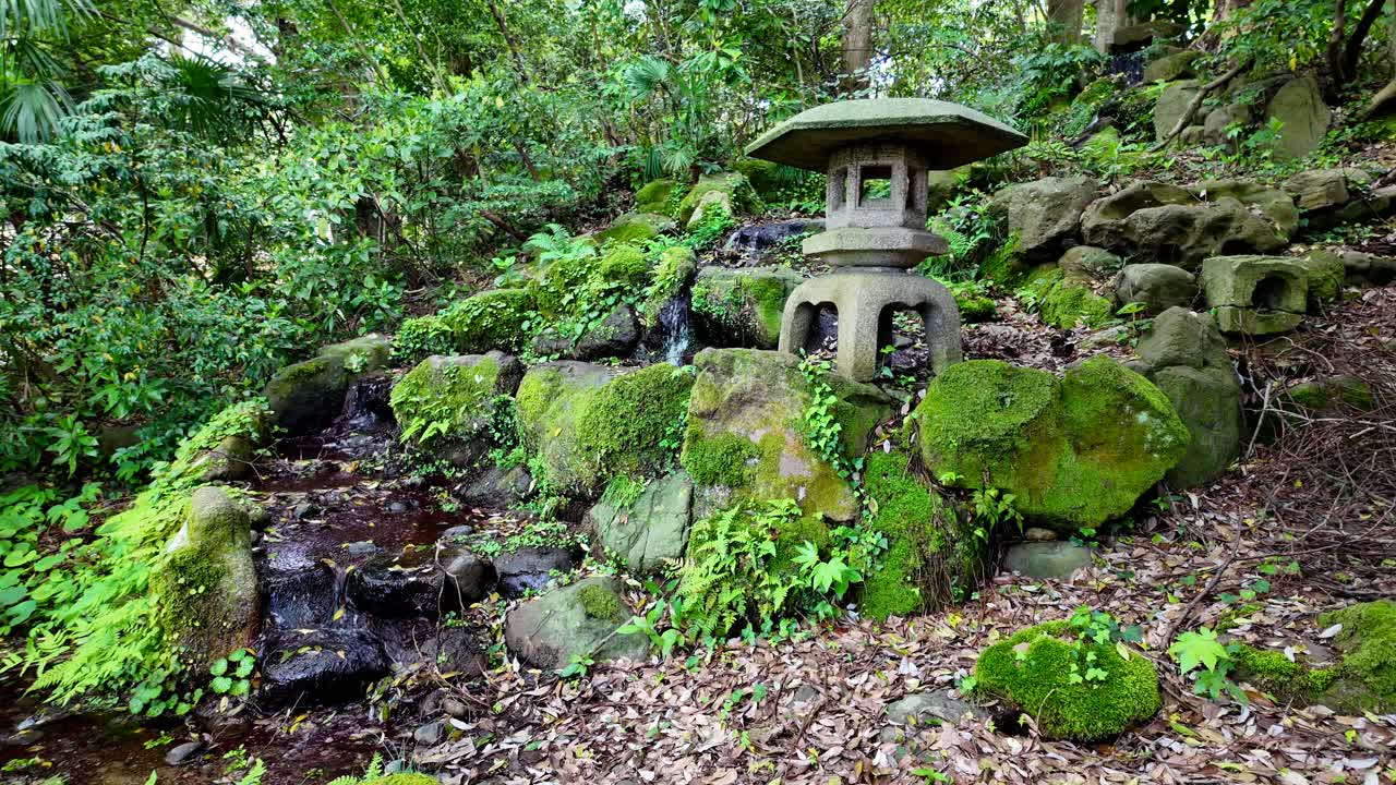 Japanese garden with pagoda ornament, stream and tiny waterfall
