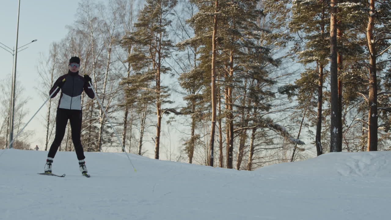 женщина катается на лыжах в зимнем лесу.