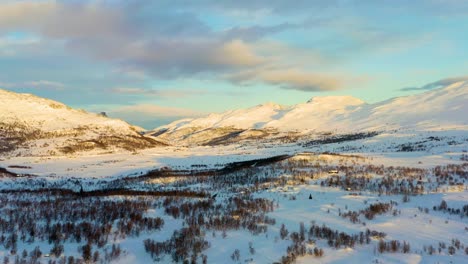 Aerial-in-low-light-over-the-snow-covered-valley-and-mountains-in-Hemsedal,-Norway