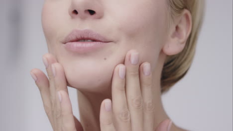 Beautiful-healthy-woman-touching-smooth-skin-on-face-in-slow-motion-for-beauty-skincare-concept-on-a-grey-background-Red-Epic-Dragon