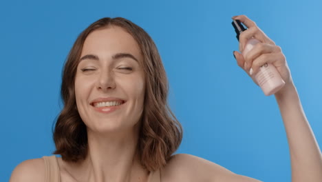 mujer aplicando un spray facial