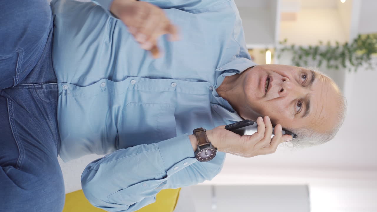 video vertical de un anciano hablando por teléfono discutiendo.