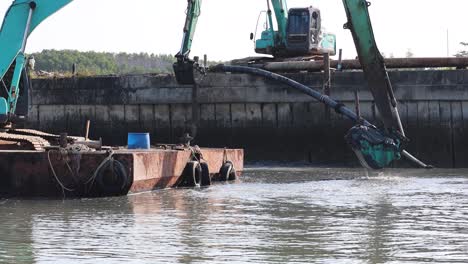 hydraulic excavator operating on a barge in water