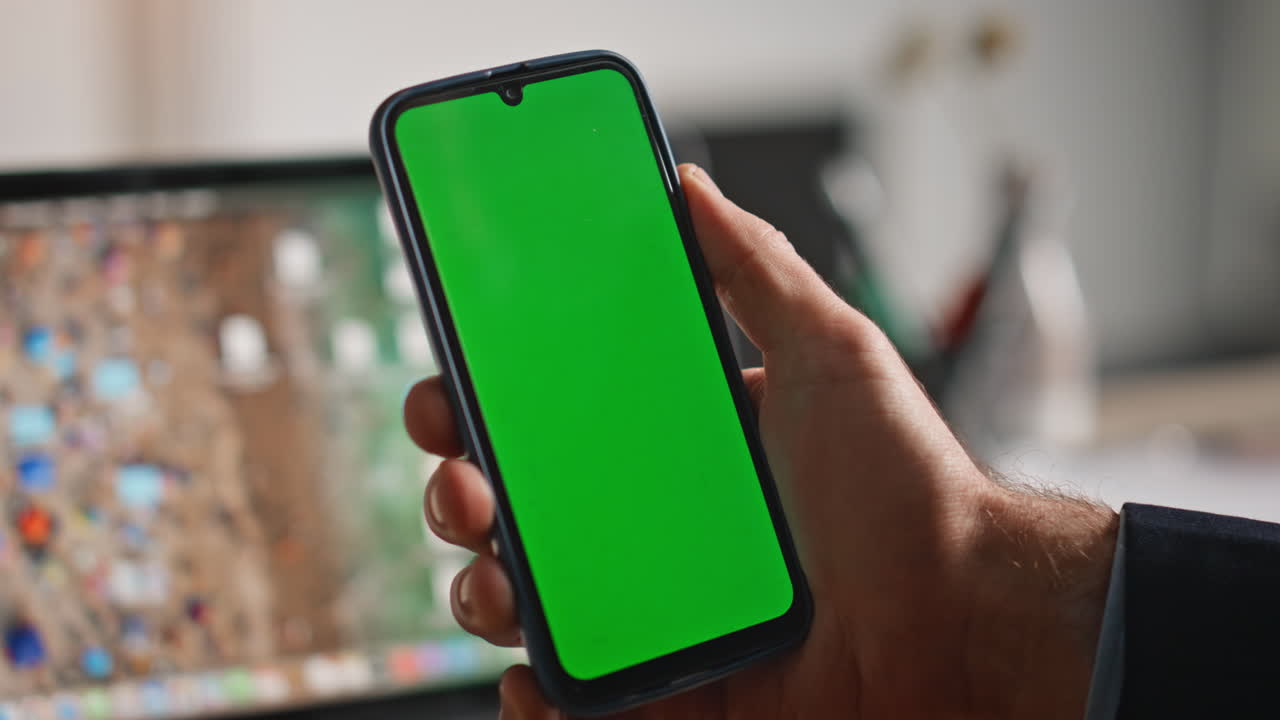 Businessman hand swiping mockup mobile phone working at laptop workplace closeup