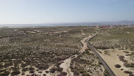 vuelo aéreo rápido sobre caminos de senderismo en la isla rural de ilha da culatra en portugal
