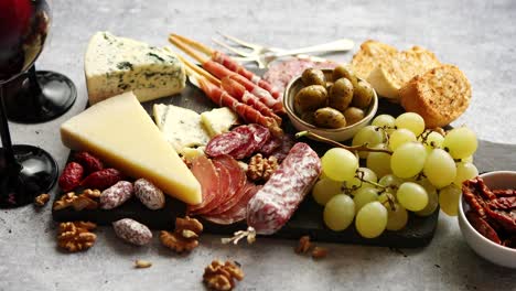 cold snacks board with meats  grapes  wine  various kinds of cheese