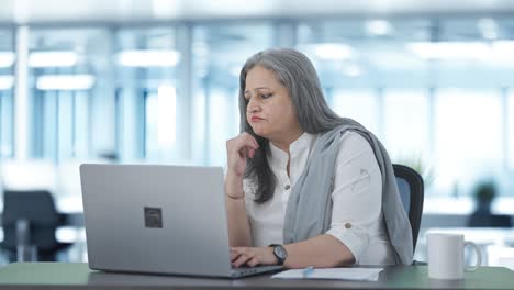 Stressed-Indian-senior-female-manager-working-on-laptop